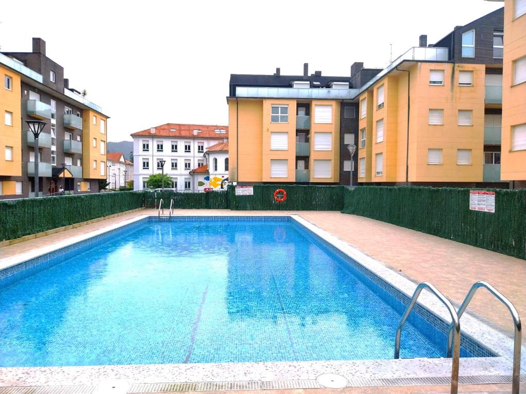 una gran piscina con edificios en el fondo en Apartamento en Unquera, en Unquera