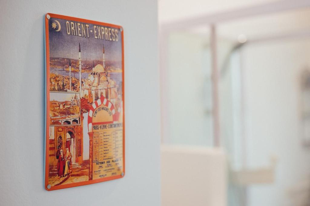 ein Plakat, das an einer Wand in einem Zimmer hängt in der Unterkunft The Orient Express No.22 in Wien