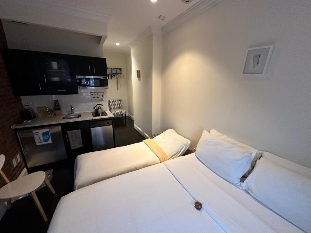 Habitación de hotel con 2 camas y cocina en East Village Hotel en Nueva York