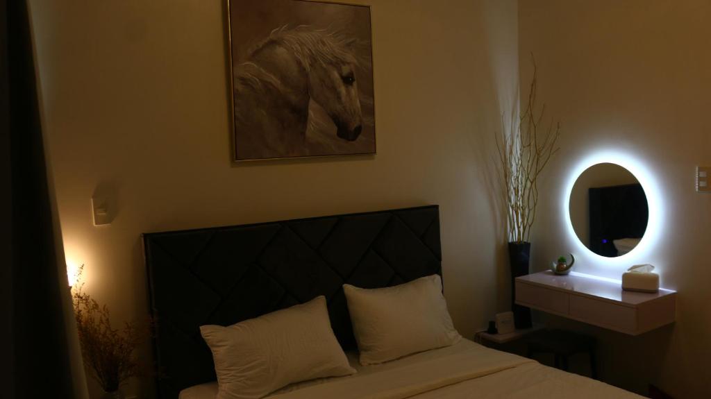 a bedroom with a bed with a picture of a horse on the wall at Triann Condo Staycation Davao in Inspiria Condominium Building in Davao City