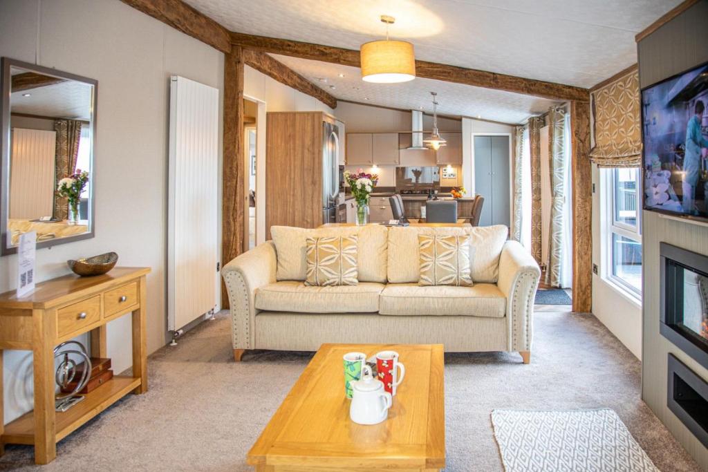 a living room with a couch and a table at Hot Tub Lodge 26 Cameron, St Andrews in St. Andrews