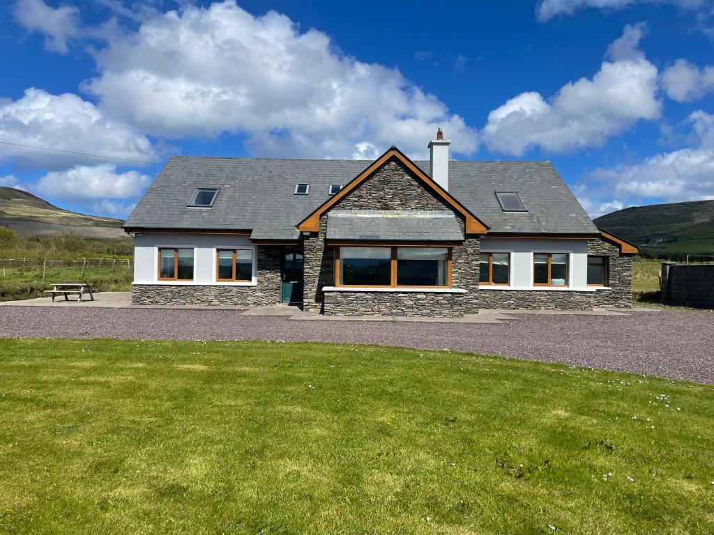 uma casa com um relvado verde em frente em Reenconnell Dingle em Dingle