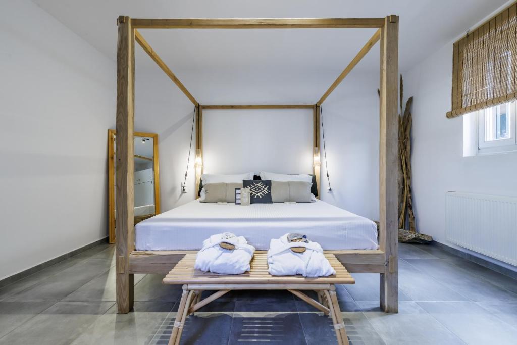 - une chambre avec un lit à baldaquin et des serviettes sur une table dans l'établissement Casa Naturale, à Skopelos