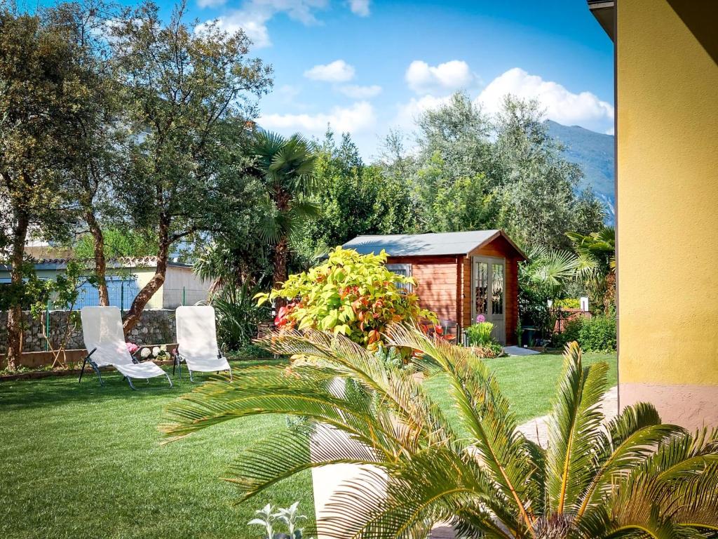 a yard with two chairs and a small shed at Villa Citrus in Riva del Garda