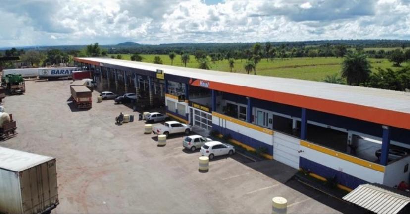un gran edificio con coches estacionados en un estacionamiento en Hotel Ipanema, en Araguaína