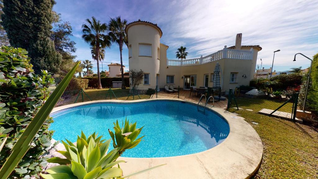 una casa con piscina delante en Villa Golden by ON Travel, en Oliva