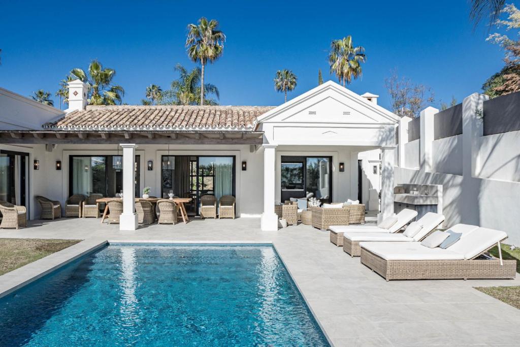 eine Villa mit einem Pool und einem Haus in der Unterkunft Villa Casiopea- Stunning holiday villa in Marbella in Marbella