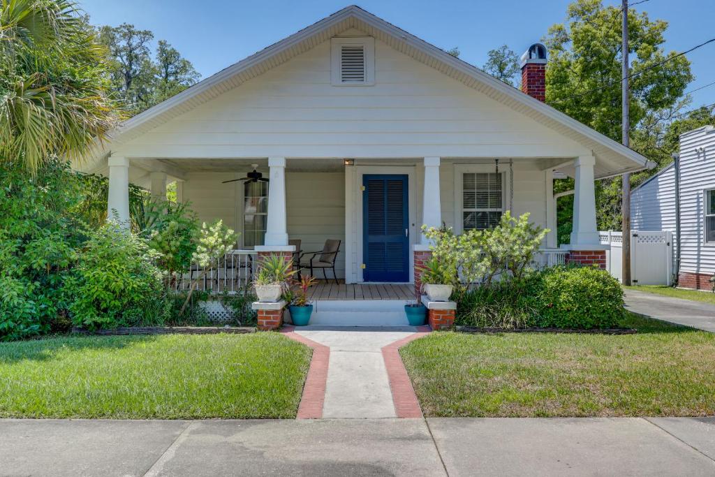 a small white house with a blue door at Beautiful Jacksonville Home Walkable Location! in Jacksonville