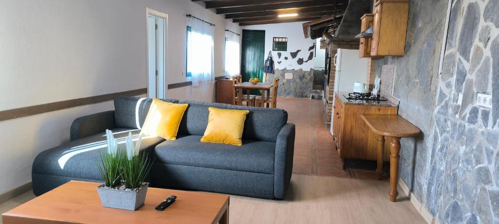 a living room with a blue couch and yellow pillows at Casa Chemar in La Orotava