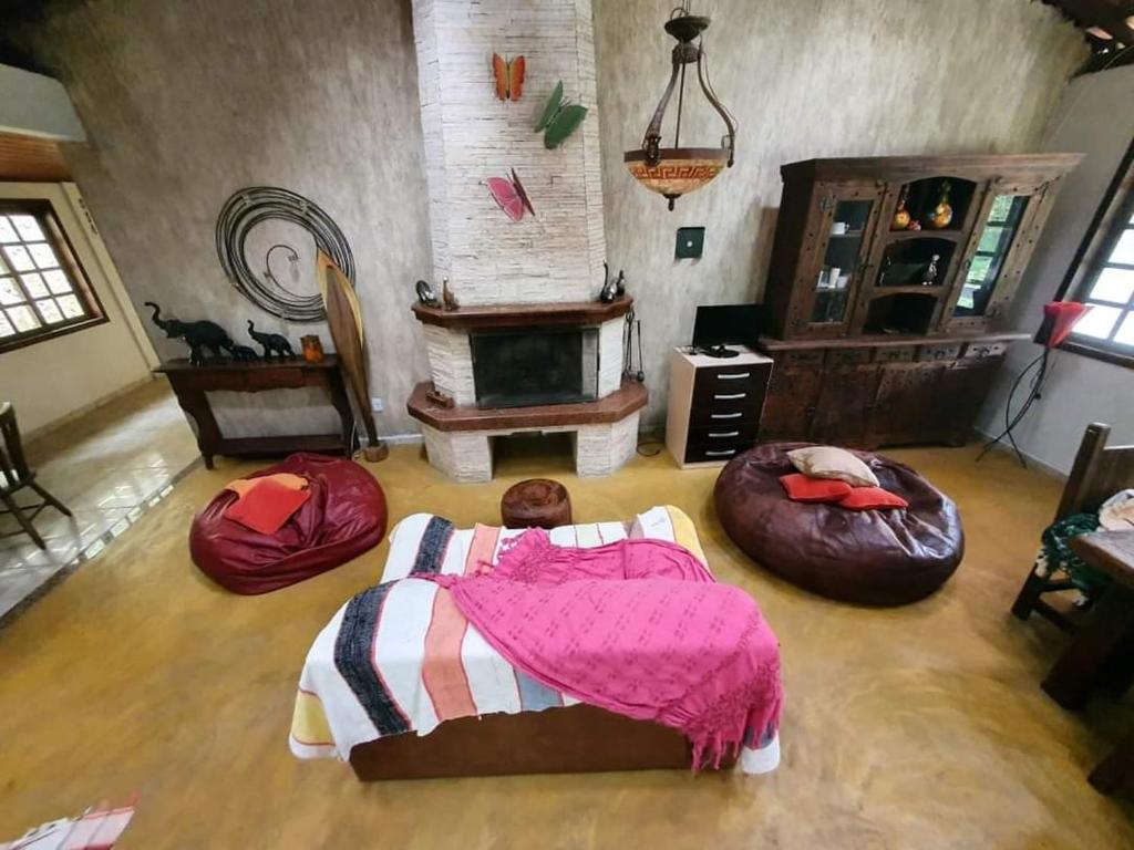 1 niño en una cama en una habitación con chimenea en Guest House sítio do Sol Penedo, en Penedo