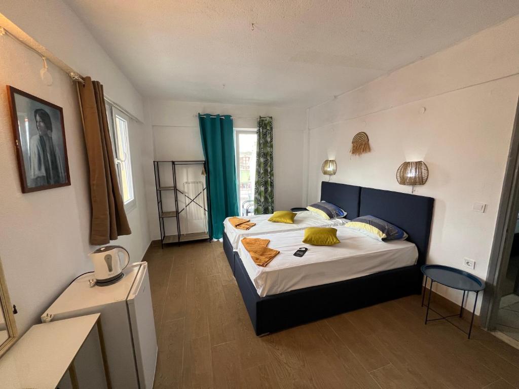 1 dormitorio con 1 cama grande con almohadas amarillas en Avra Boutique en Benitses