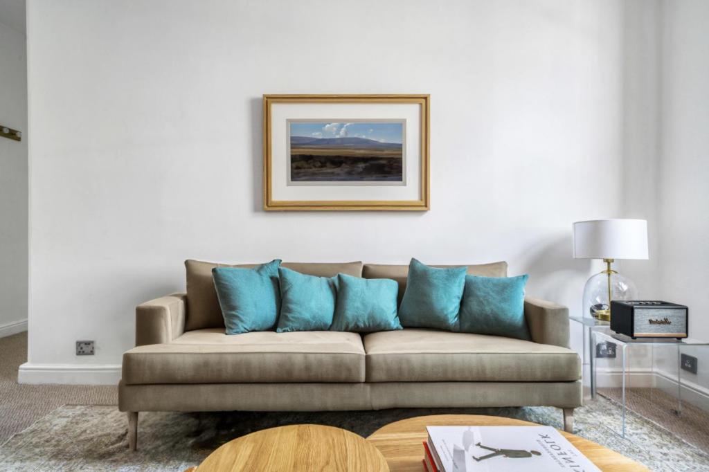 sala de estar con sofá y almohadas azules en Lovely Spot by City of London en Londres