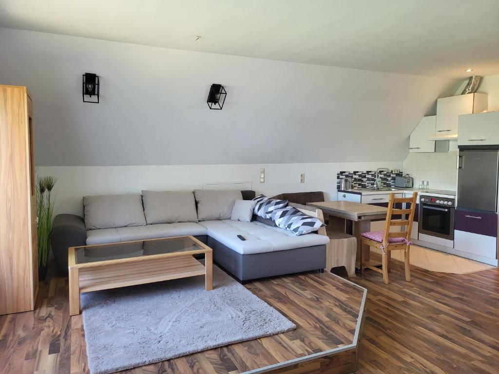 uma sala de estar com um sofá e uma mesa em Komplette 4 Zimmer OG Wohnung em Langwedel