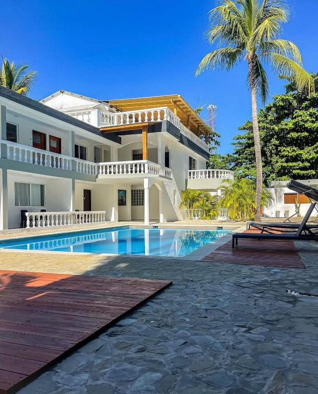 uma casa com uma piscina e uma palmeira em HUMMINGBIRD CABARETE em Cabarete