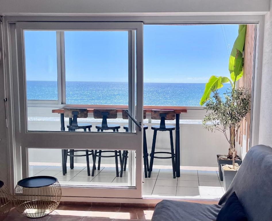- un salon avec une table et une vue sur l'océan dans l'établissement face mer, à Saint-Hilaire-de-Riez
