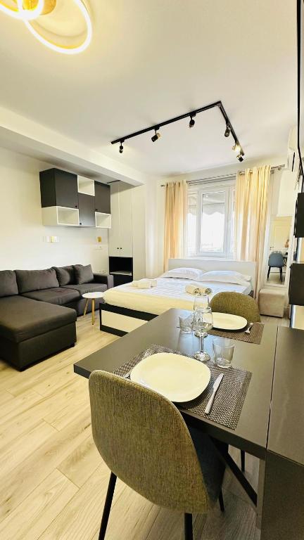 ein Wohnzimmer mit einem Bett und einem Esstisch in der Unterkunft Studio Apartment 24/7 Self Check-in in Tirana
