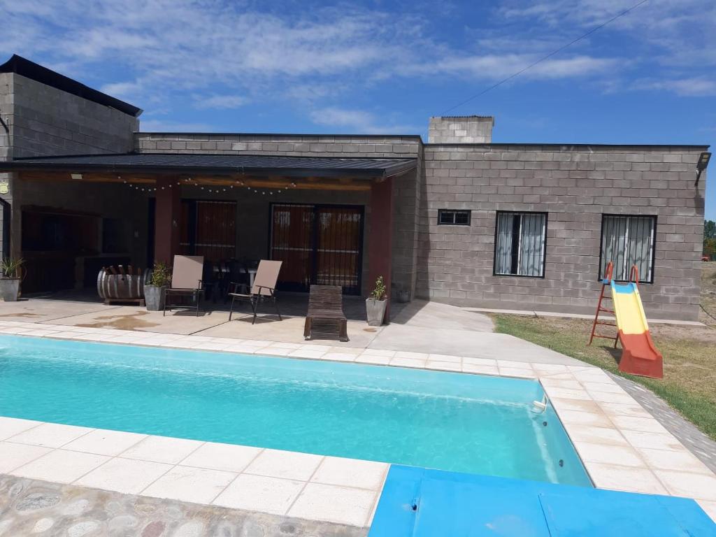 una casa con piscina frente a ella en PAJARO BLANCO en San Rafael