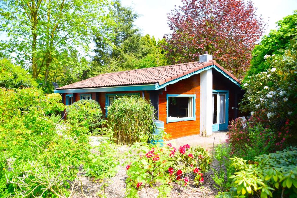 ein kleines Haus inmitten eines Gartens in der Unterkunft Sfeervol houten huis I Bosrijk Veluwe in Putten