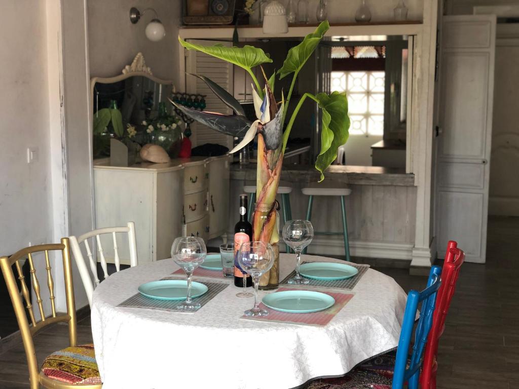 una mesa con platos y copas de vino y una planta en Dúplex con vistas panorámicas, en Calabardina