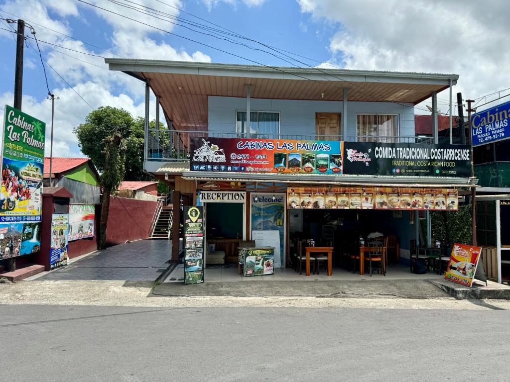 a store on the side of a street with a building at Cabinas Las Palmas del Sol in Fortuna