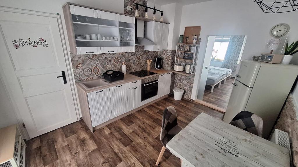 eine Küche mit einem Kühlschrank, einer Spüle und einem Tisch in der Unterkunft Pauls Hexenhaus Wohnung Teufel mit Familienbett in Thale