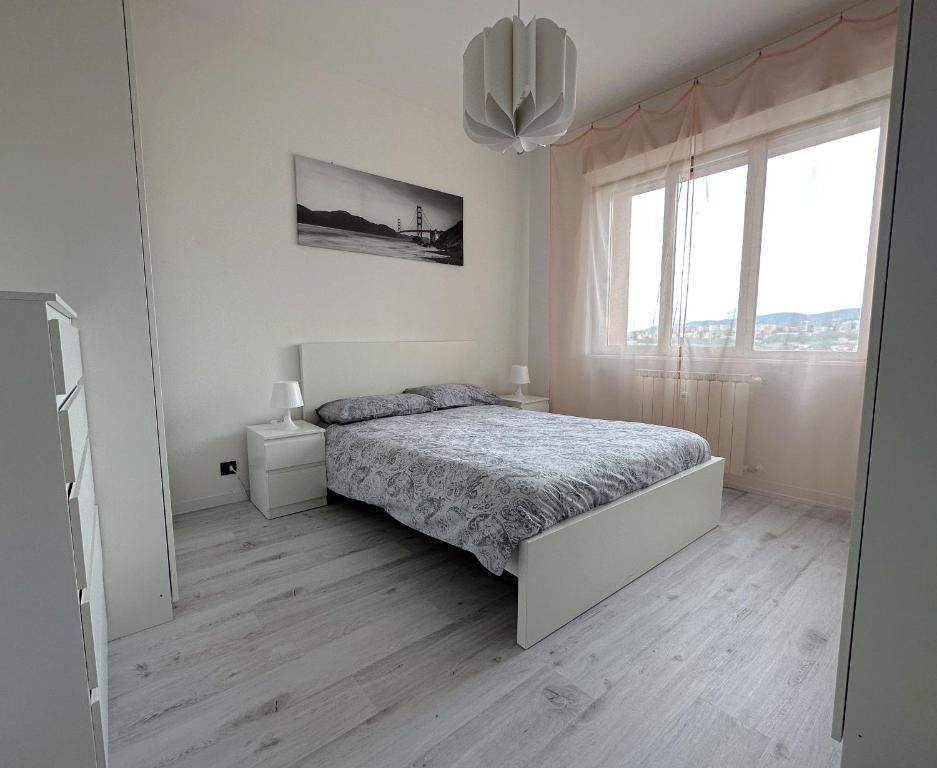 - une chambre blanche avec un lit et une fenêtre dans l'établissement NUOVO Appartamento Bora Scura, à Trieste