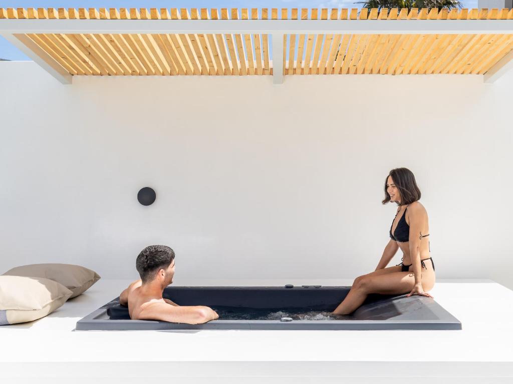 a man and a woman sitting in a hot tub at Casa Naturale in Skopelos Town