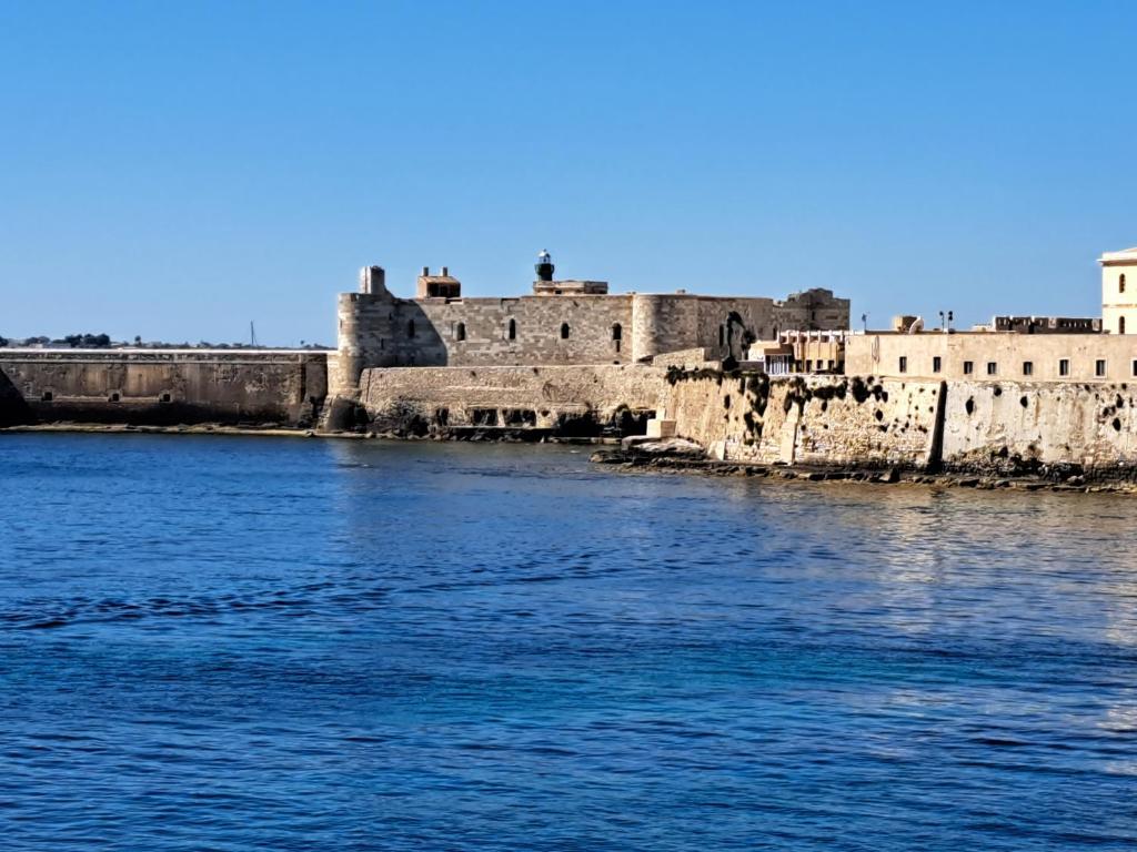 a view of a river with an old building at Ortigia L'Antico Dammuso in Syracuse