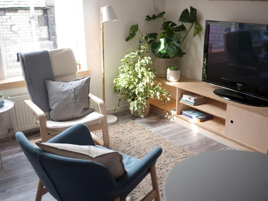 sala de estar con 2 sillas y TV de pantalla plana en Contemporary City Studio Apartment 2 Minutes from Station en Aberdeen