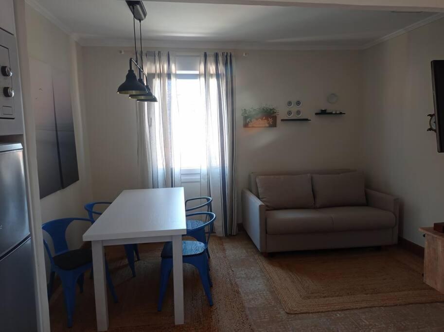 eine Küche und ein Wohnzimmer mit einem Tisch und einem Sofa in der Unterkunft Erizana in Baiona