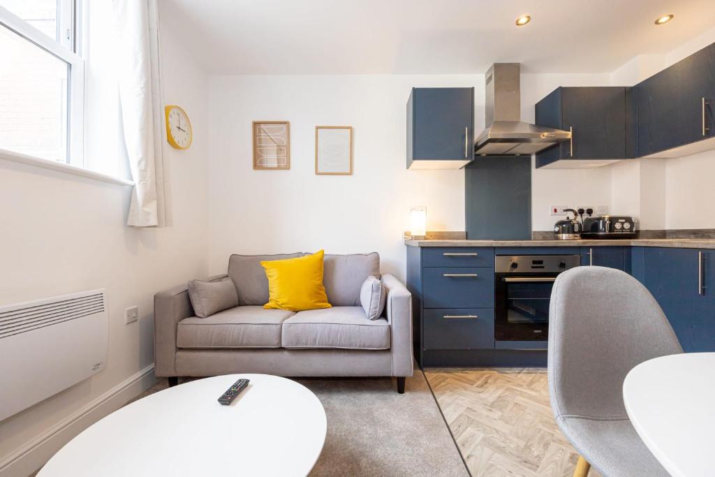 un soggiorno con divano e una cucina di Beautiful 1 bed 20mins to Central Manchester a Bolton