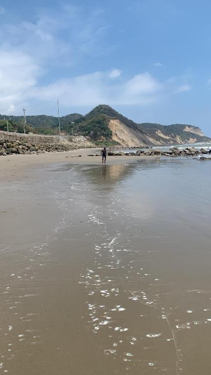 una persona caminando en el agua en una playa en Casa heysol en Bahía de Caráquez
