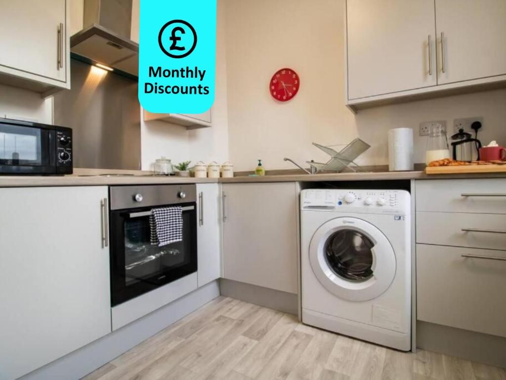 una cucina con lavatrice e forno a microonde di Cosy 1BR Retreat in Sunderland - Flat 3 a Sunderland