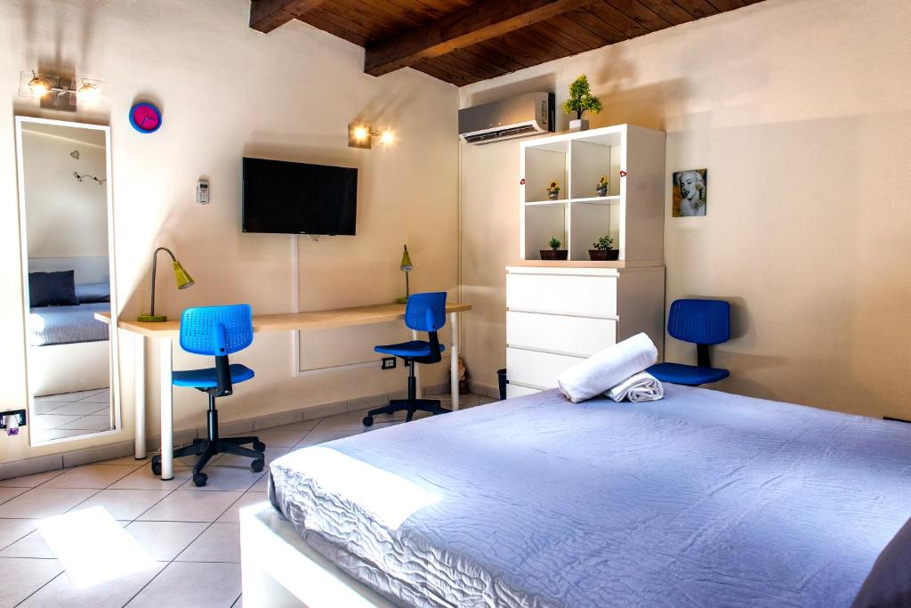 Un dormitorio con una cama y un escritorio y sillas. en Palermo Central Apartments, en Palermo