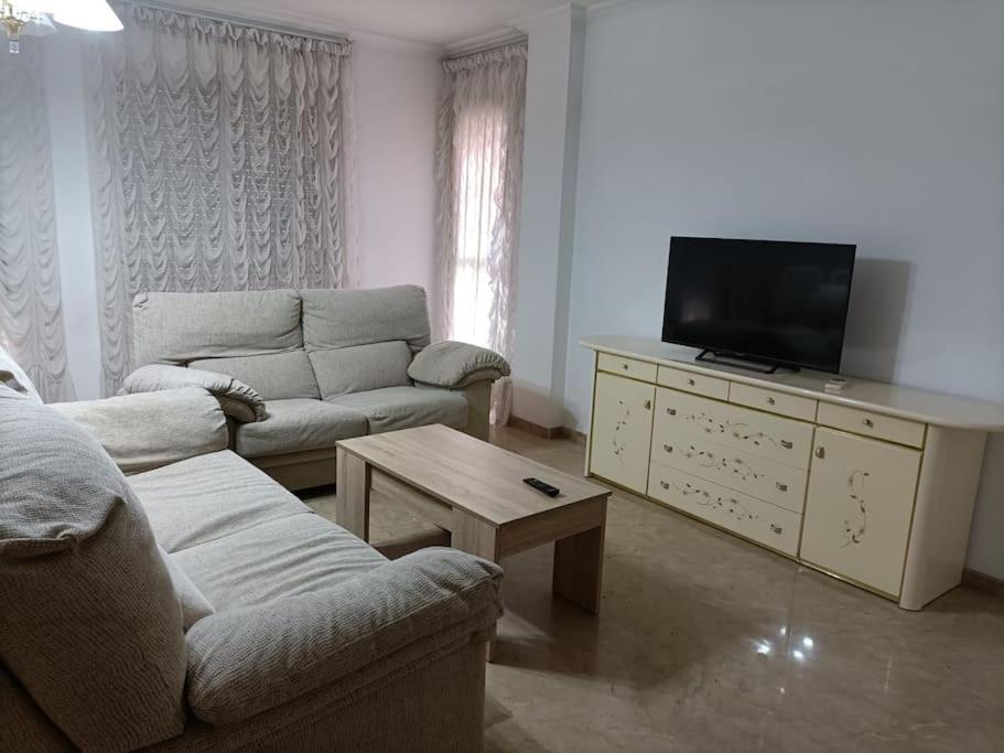 ein Wohnzimmer mit 2 Sofas und einem Flachbild-TV in der Unterkunft apartamento céntrico en Lorca in Lorca