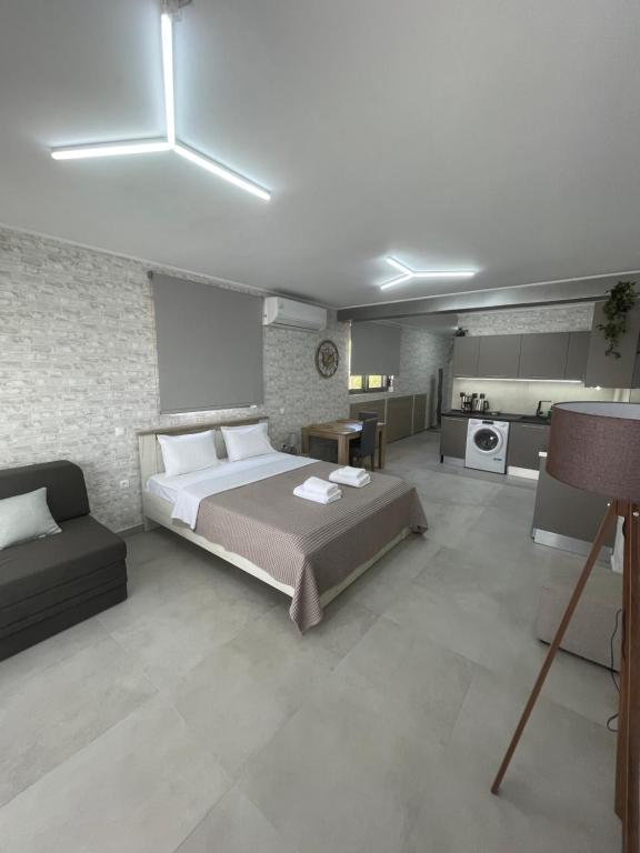 um quarto com uma cama grande e uma cozinha em AVR Airport Deluxe Suites 6 em Markopoulo Mesogaias