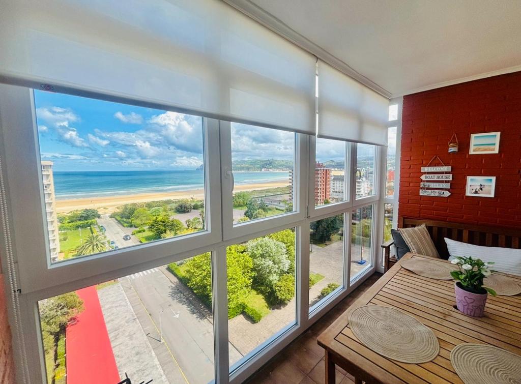 um quarto com uma grande janela com vista para a praia em APARTAMENTO el PUNTAL- LAREDO em Laredo