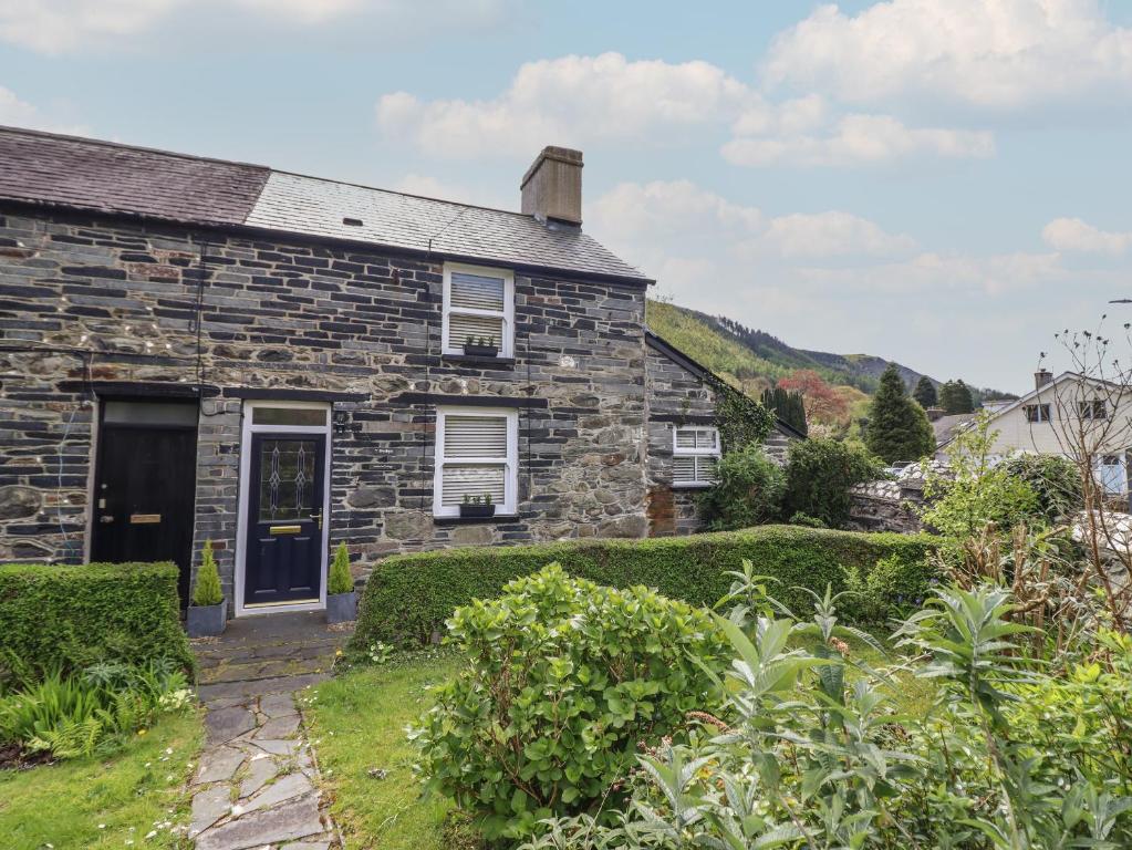an old stone house with a garden at Arthurs Cottage in Tywyn