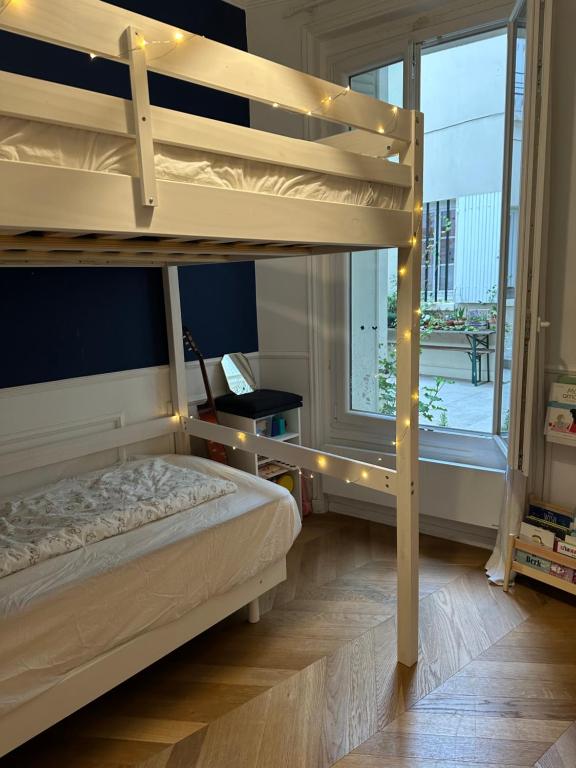 a bedroom with two bunk beds and a window at Paris 16 lux and cozy 2 bedroom in Paris
