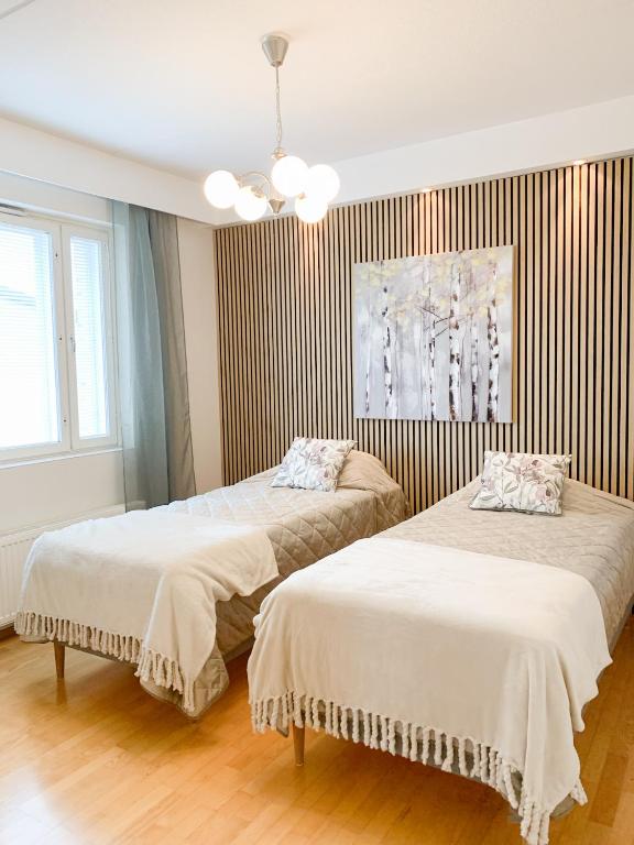 - une chambre avec 2 lits et un lustre dans l'établissement Rovaniemi City Centre Apartment, private sauna, à Rovaniemi