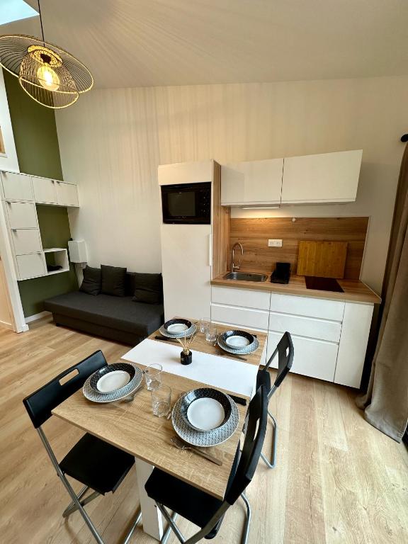 a kitchen with a table and chairs in a room at Studio "Cocon Suspendu" 4 pers-Terrasse-Clim-Barbecue-15km des plages in Montpellier