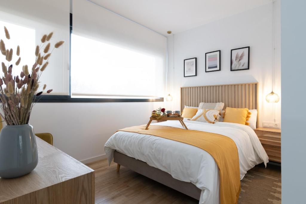 a bedroom with a bed and a vase of flowers at Dorm4You Arena Standar Junior in Valencia