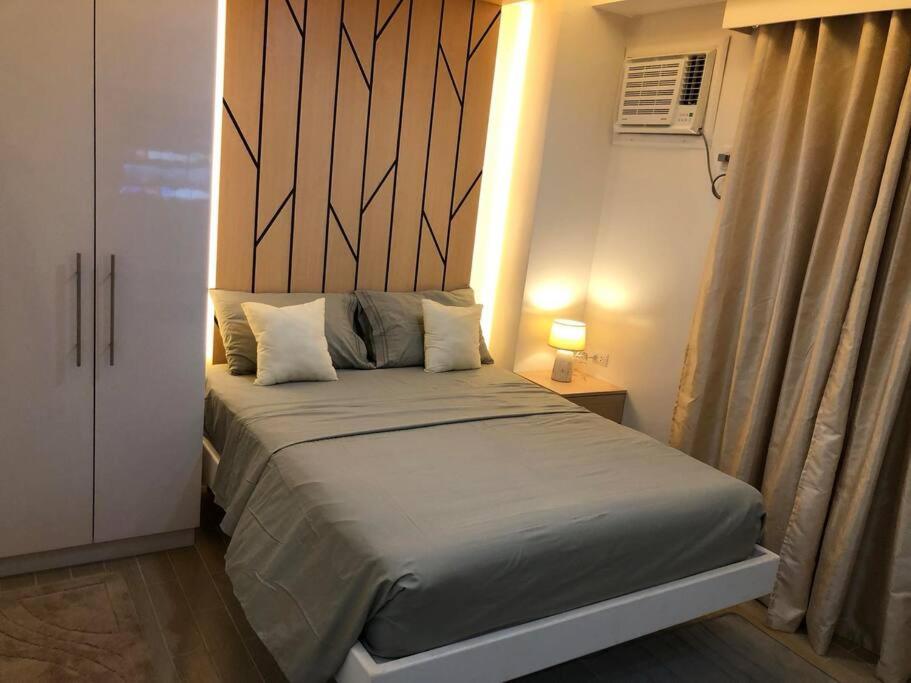 um quarto com uma cama e uma cabeceira em madeira em Executive Traveller em Iloilo