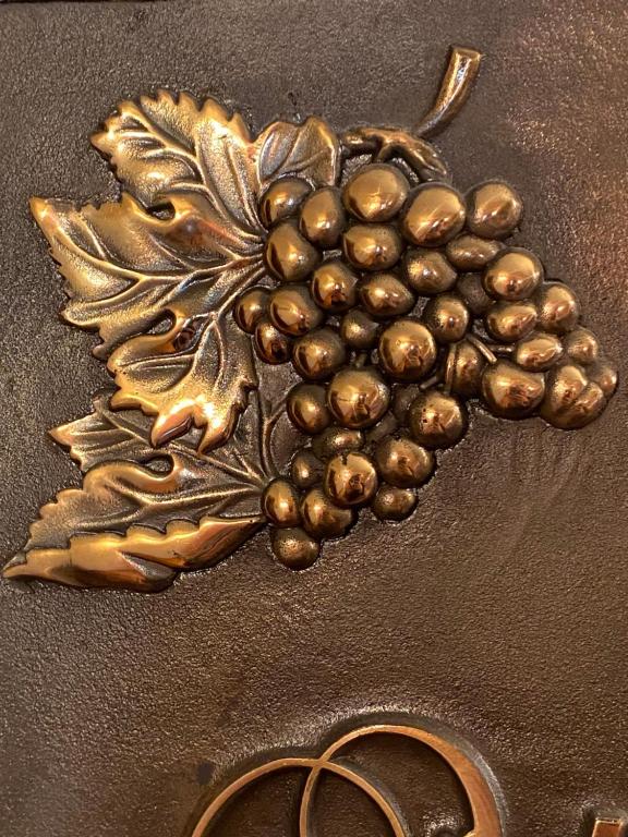 a gold brooch with a bunch of grapes and a pair of shoes at Hotel Finca Malvasia in Cabezón de Liébana