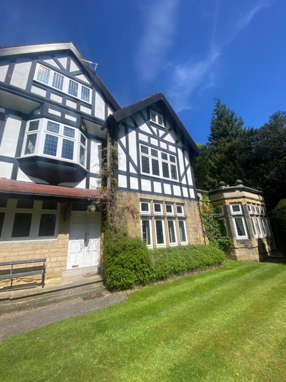 an old black and white house with a yard at Spacious Guest Flat near Roundhay Park in Roundhay