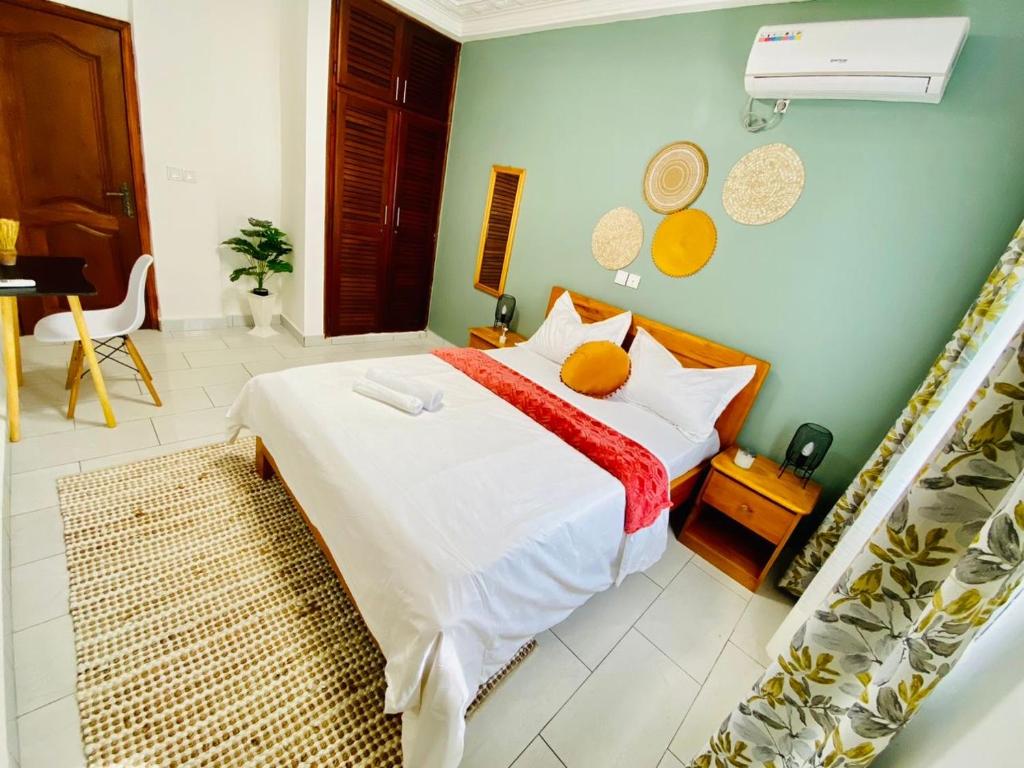 ein Schlafzimmer mit einem großen weißen Bett mit einer roten Decke in der Unterkunft Appartement meublé 2 Chambres, Salon - Bastos, Ambassade du Tchad, Yaoundé, CMR in Mbala