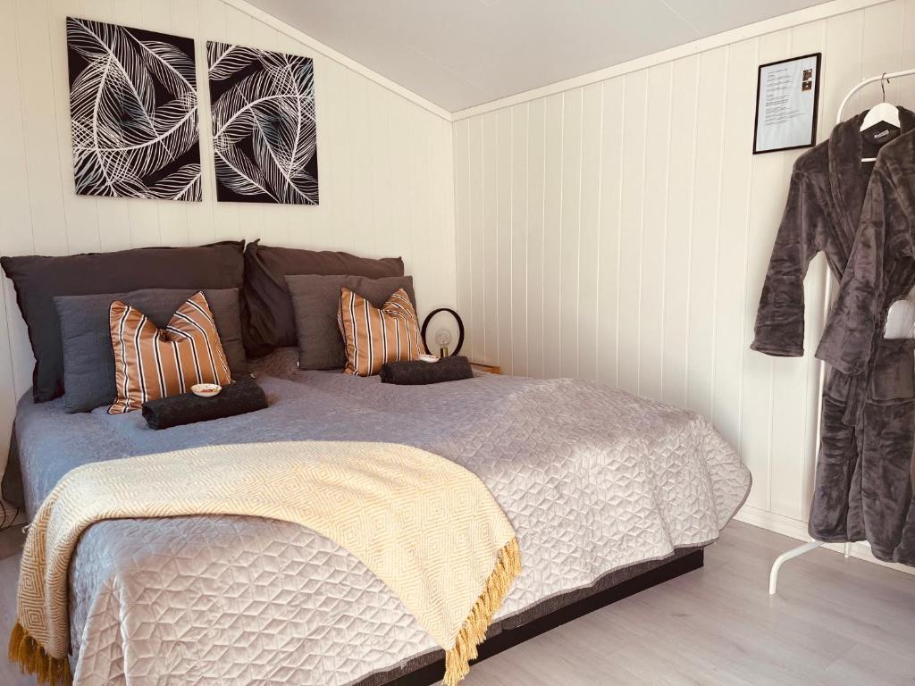 una camera da letto con un letto con cuscini sopra di Brightside Apartment a Kristiansand