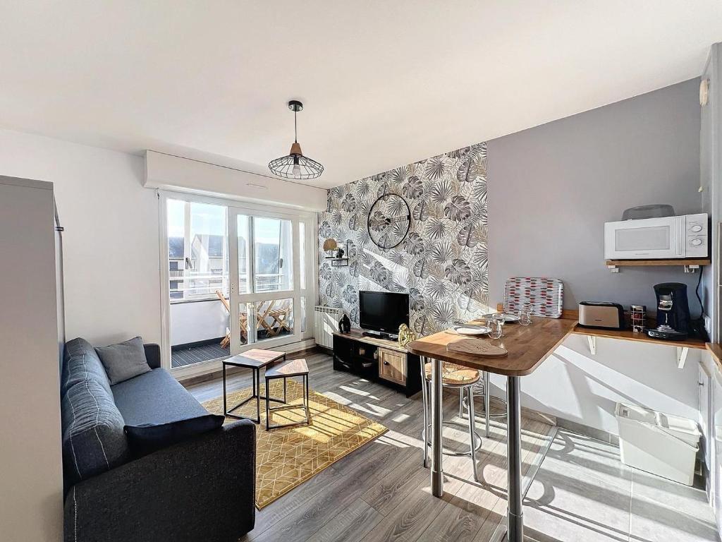 un salon avec un canapé et une table dans l'établissement JUNO Appart, à Courseulles-sur-Mer