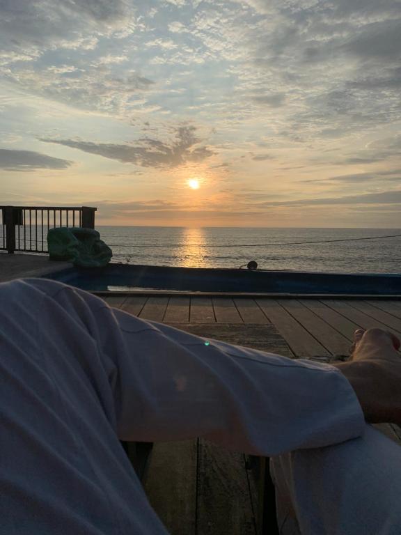 un hombre tendido en la playa mirando la puesta de sol en Casa heysol en Bahía de Caráquez