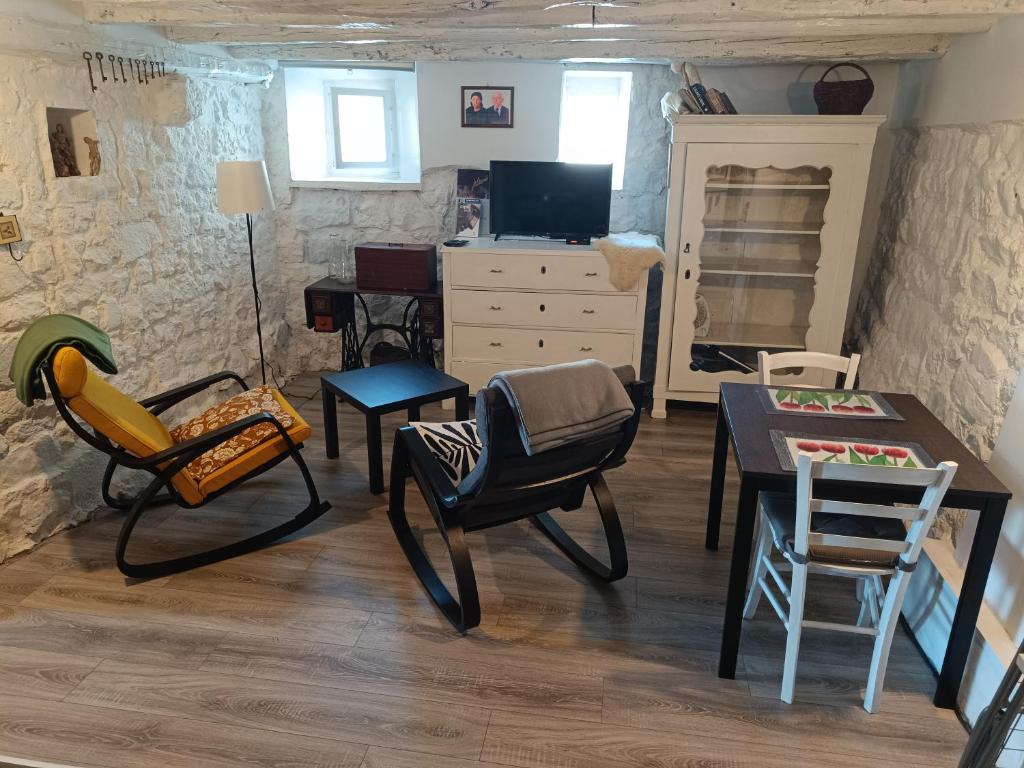 ein Wohnzimmer mit Stühlen und einem Tisch in der Unterkunft Hobbit house lubenice in Lubenice